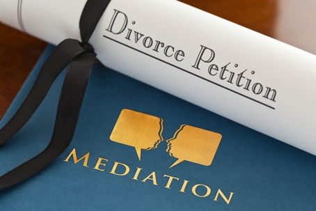 A rolled "Divorce Petition" document, tied with a black ribbon